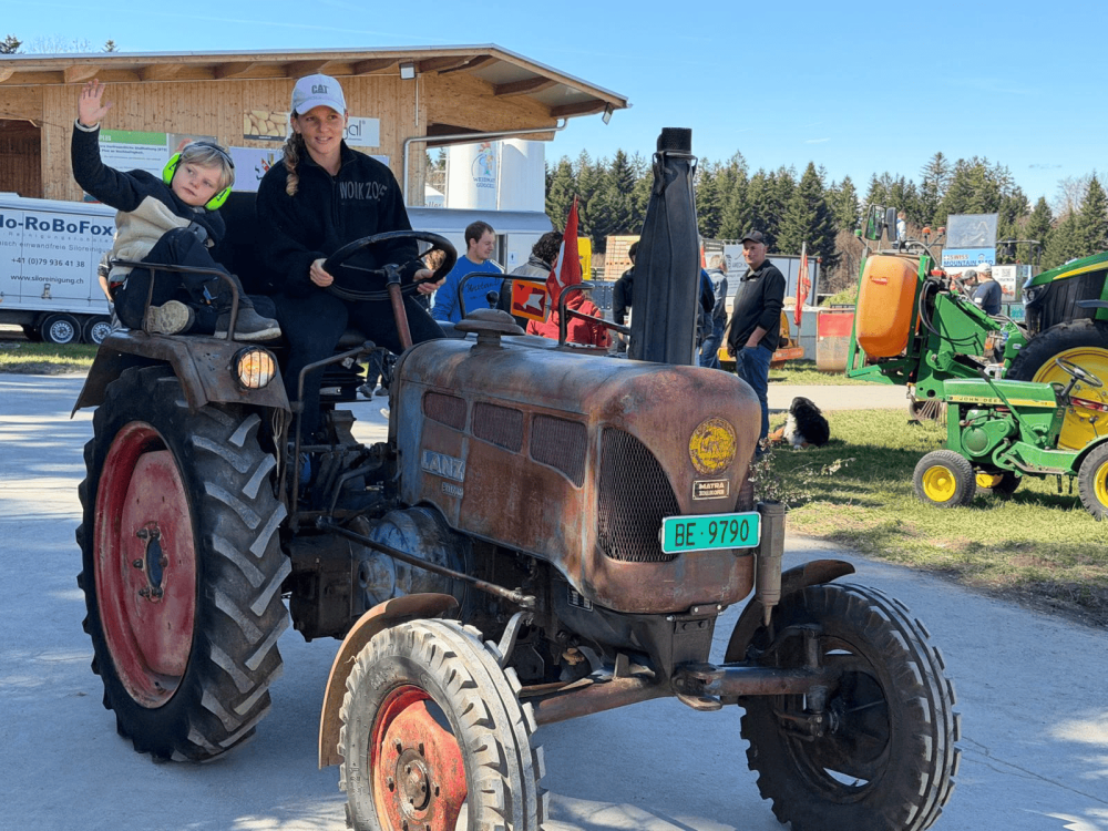 Frau mit Sohn auf einem Oldtimer-Traktor