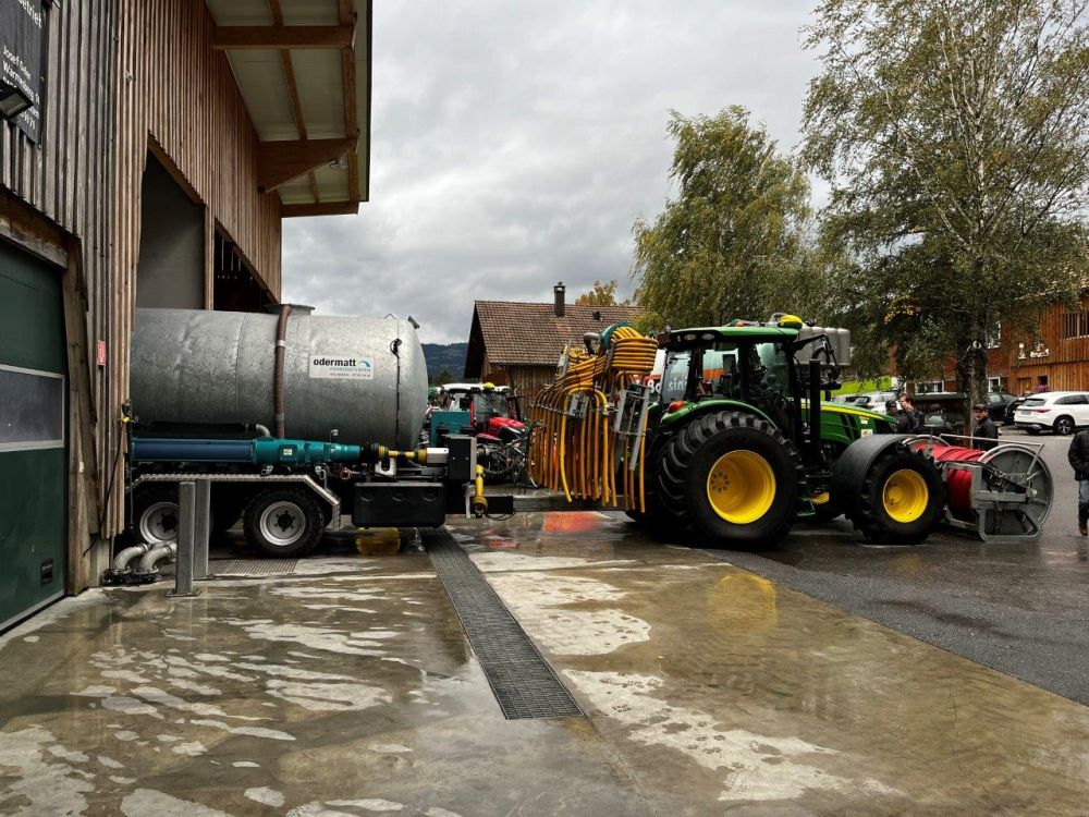 Un John Deere 5125R avec un distributeur de tuyaux traînés et un camion-pompe d'Odermatt Umwelttechnik. Image : kim